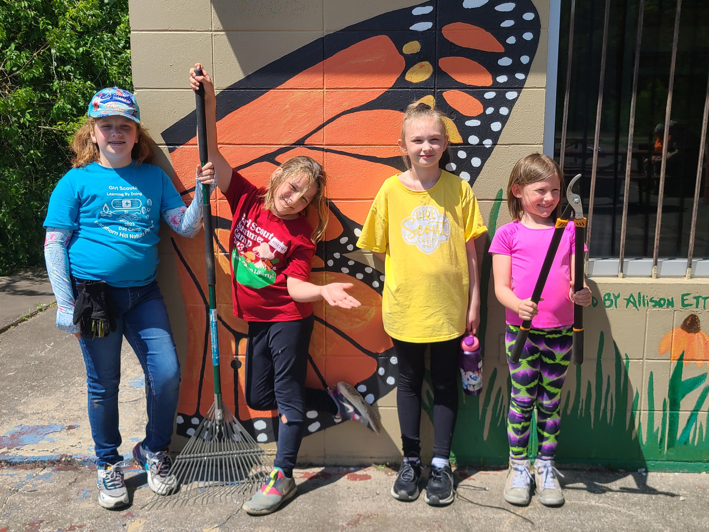 kid volunteers in front of a mural at the Lakeside Nature Center